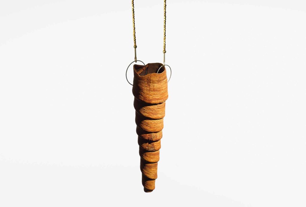 <em>Cornucopia</em> pendant, 2013. Cinamon, steel, bronce, gold. Photo Sebastian Ahlers.