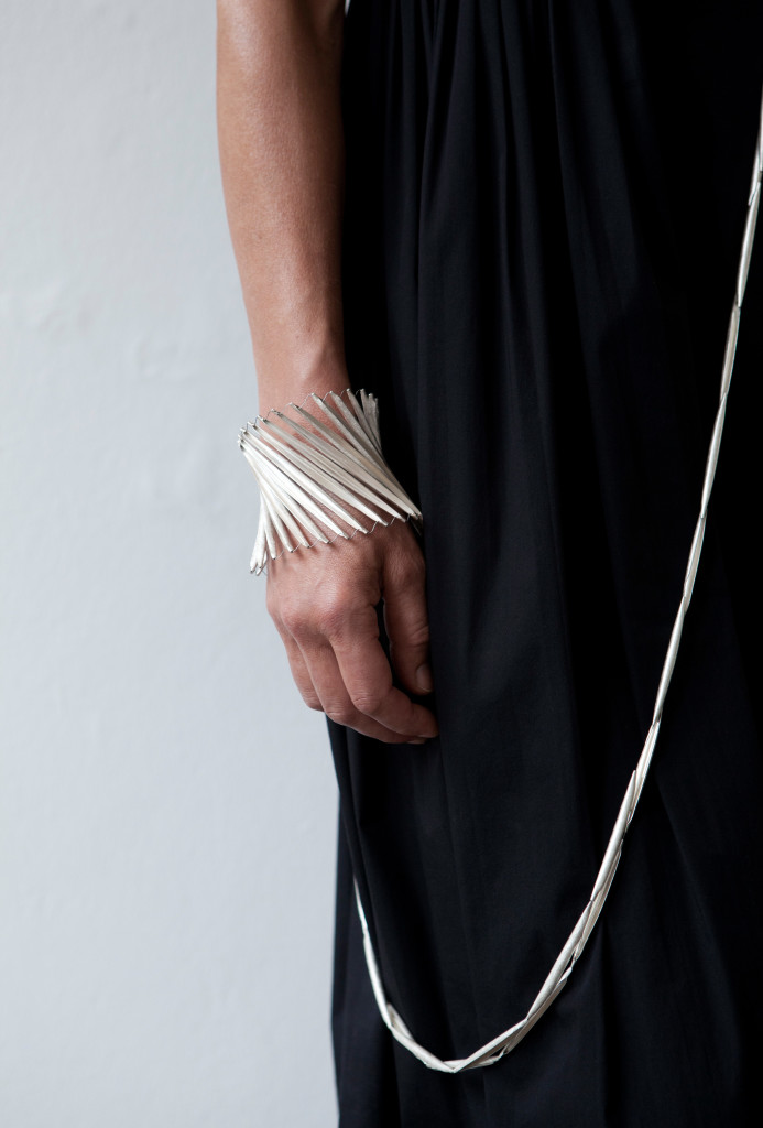 <em>Schotenarmschmuck torsion</em> bangle. 925 silver, steel silk & <em>Lineare Schotenkette</em> necklace. 925 silver, steel silk. Photo Miriam Künzli.
